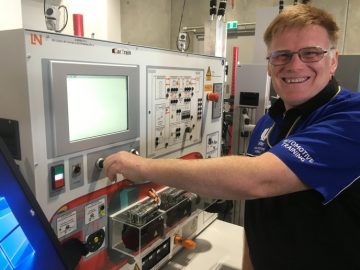 Vehicle systems lecturer Lee Bagelow with a Car Train computerised desk.