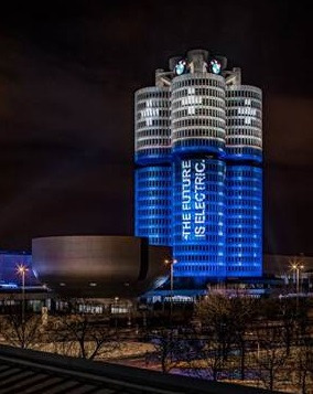 BMW Group’s headquarters tower in Munich lit up like a battery.