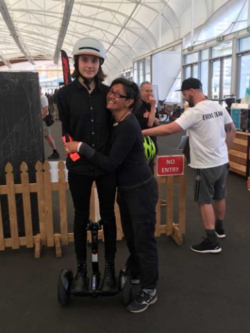 Nikita Hoff-Nielsen from Bikes & Barbers tests a Segway Ninebot with help from mum Darleen.