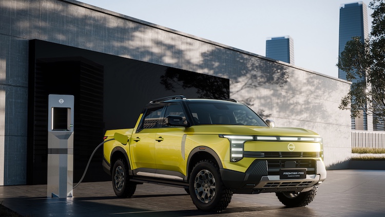 Yellow Nissan Frontier Pro plugged into a charger outside a building