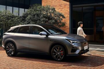 Arcfox T5 electric SUV parked outside a brick building