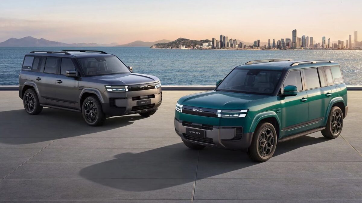 Two BYD Ti 7 SUVs in grey and green by the coast