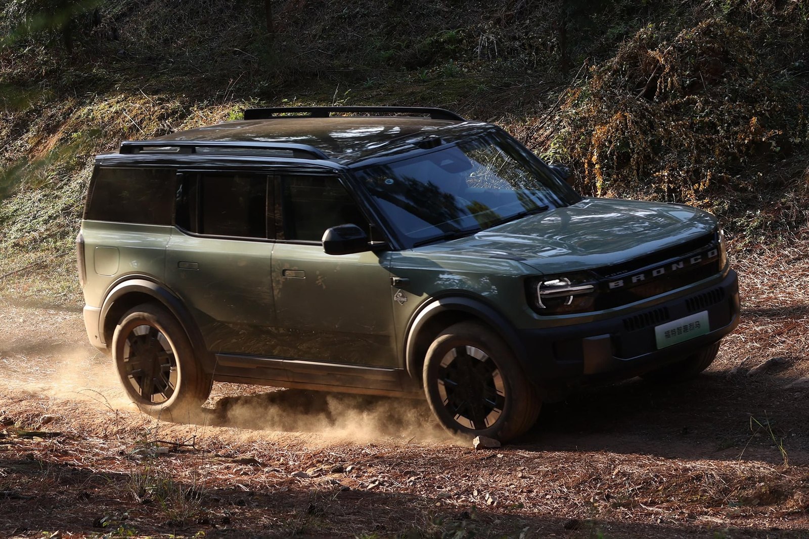 Green Ford Bronco New Energy driving on a dirt trail