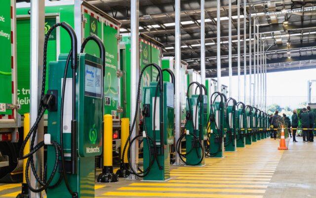 Row of Woolworths EV chargers with electric delivery trucks at the Penrose hub