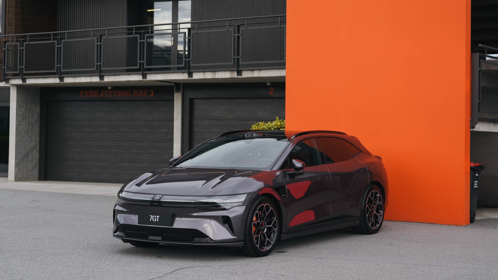 Maroon Zeekr 7GT parked against an orange wall at Highlands