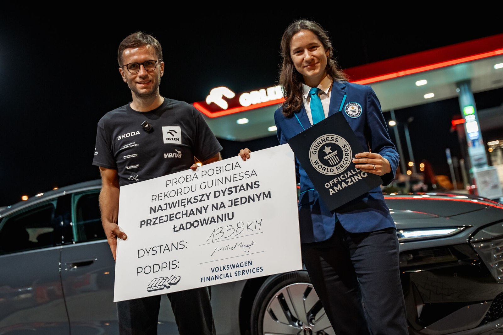 Miko Marczyk and a Guinness World Records adjudicator with the record certificate beside the Audi A6 e-tron