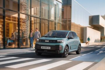 New Dacia Spring in Agave blue on a city street