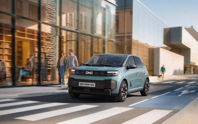 New Dacia Spring in Agave blue on a city street