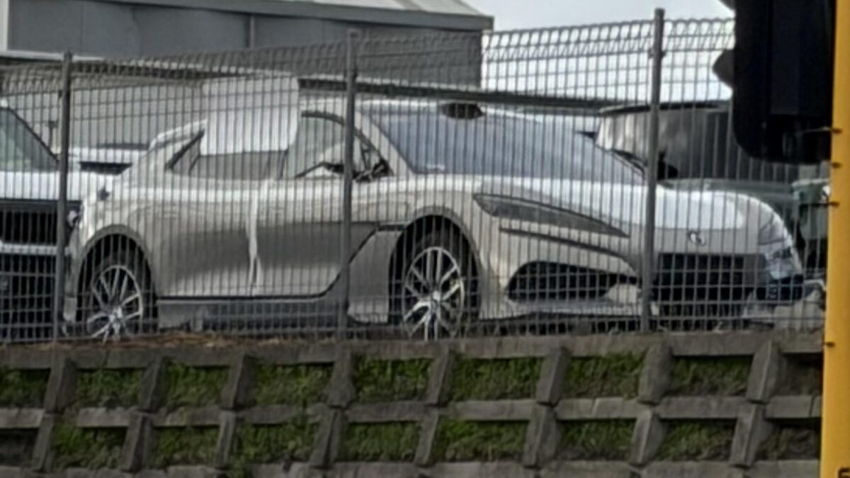 Silver Denza Z9GT behind a fence in an Auckland vehicle storage yard beside a Denza B8