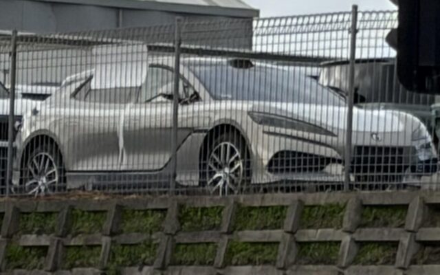 Silver Denza Z9GT behind a fence in an Auckland vehicle storage yard beside a Denza B8