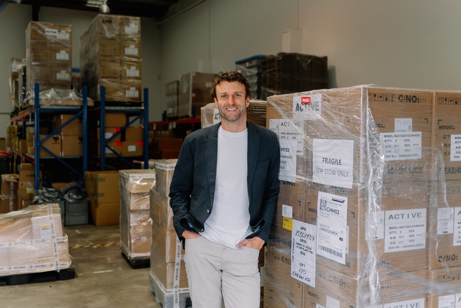 Ed Harvey in the Evnex warehouse with pallets of chargers