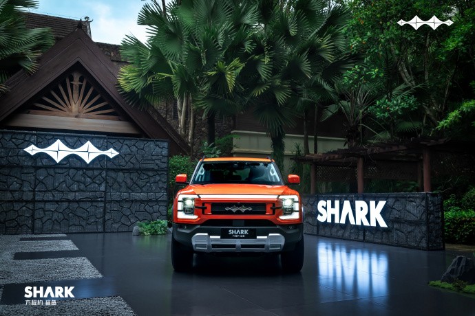Orange Fang Cheng Bao Shark ute front view beside a Shark sign