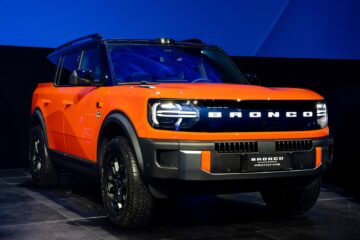 Orange Ford Bronco Basecamp front three quarter on stage