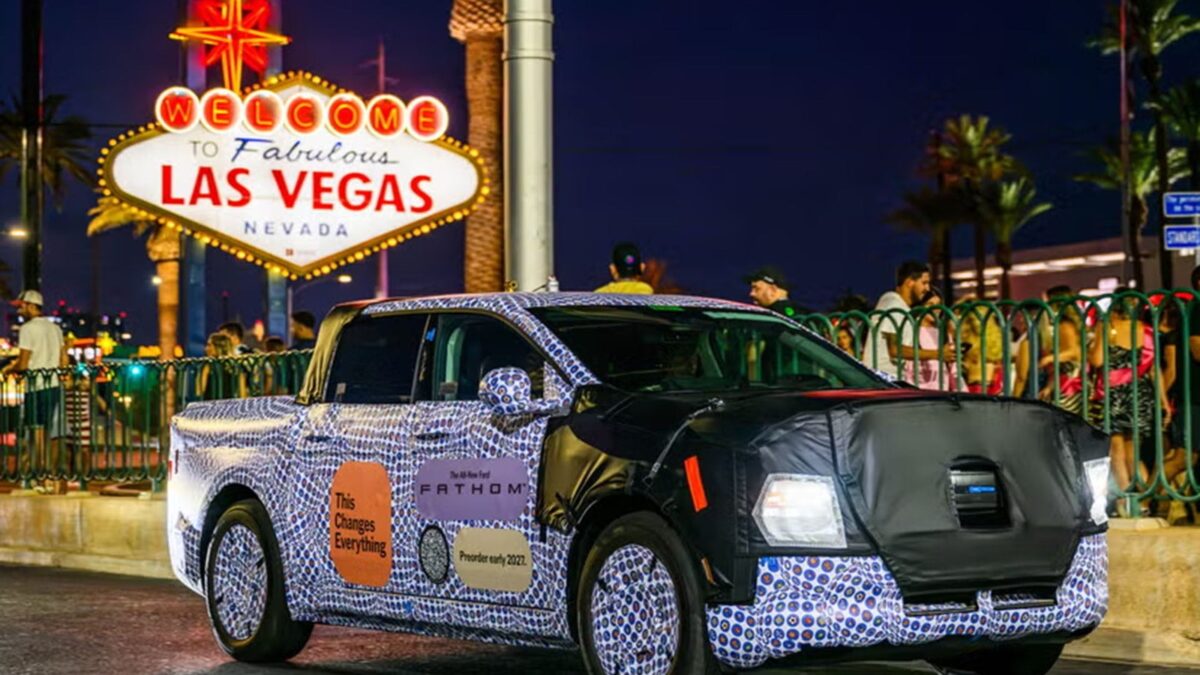 Camouflaged Ford Fathom electric ute in front of the Welcome to Las Vegas sign