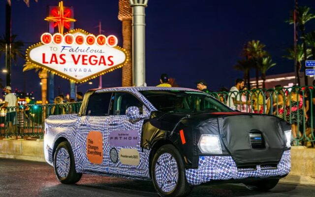Camouflaged Ford Fathom electric ute in front of the Welcome to Las Vegas sign
