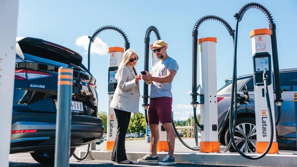 Two EV drivers at a multi-plug Kempower charging site