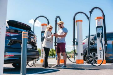 Two EV drivers at a multi-plug Kempower charging site
