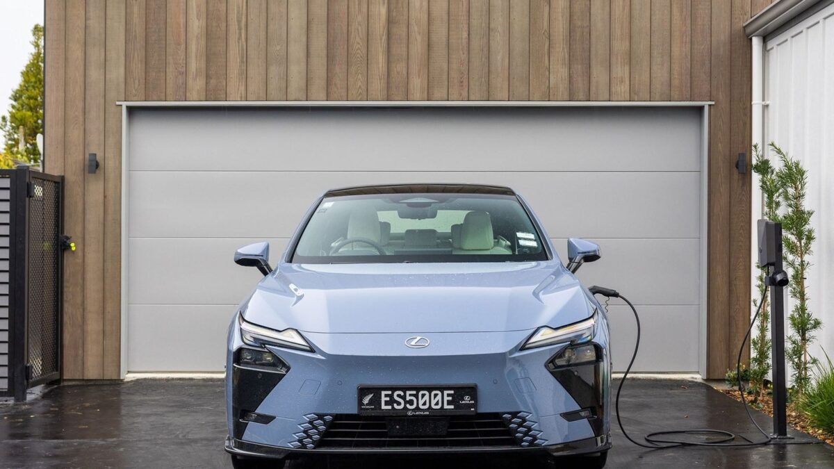 Blue Lexus ES 500e charging outside a garage