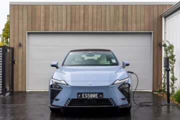 Blue Lexus ES 500e charging outside a garage