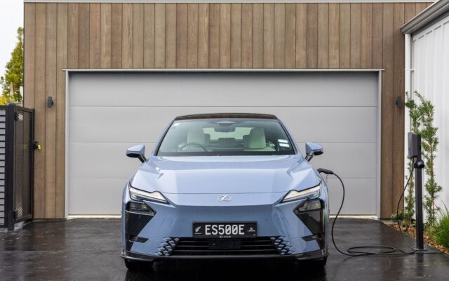 Blue Lexus ES 500e charging outside a garage
