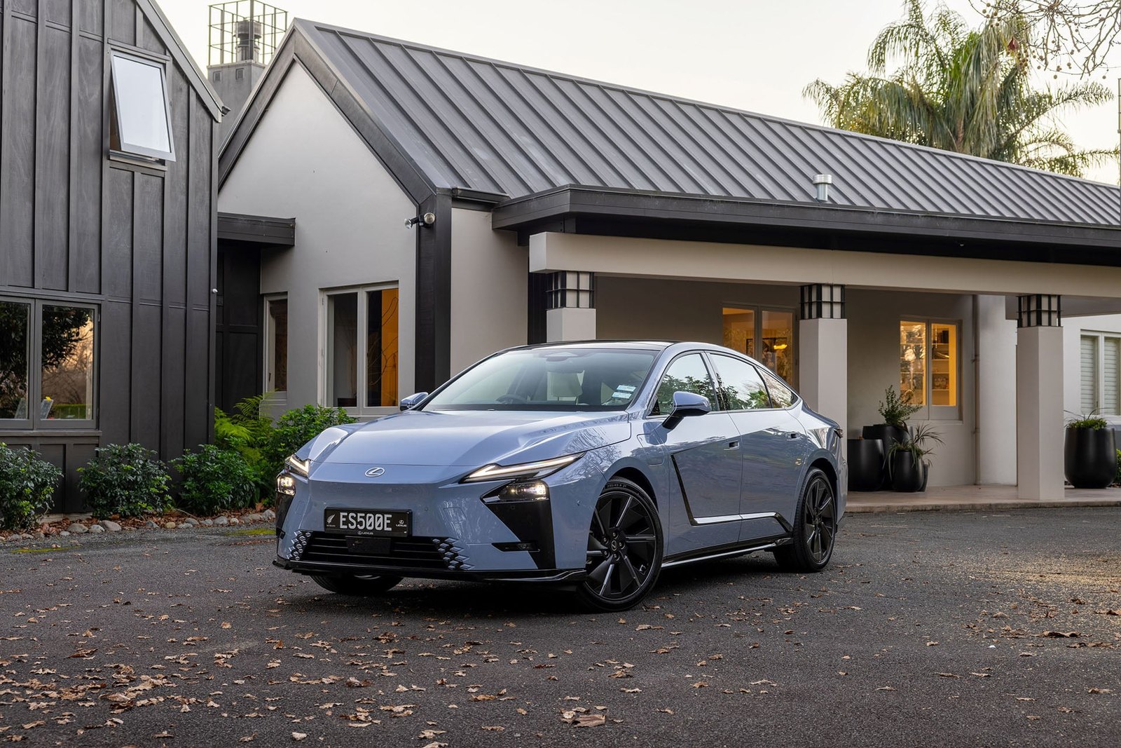 Blue Lexus ES 500e front three quarter outside a house