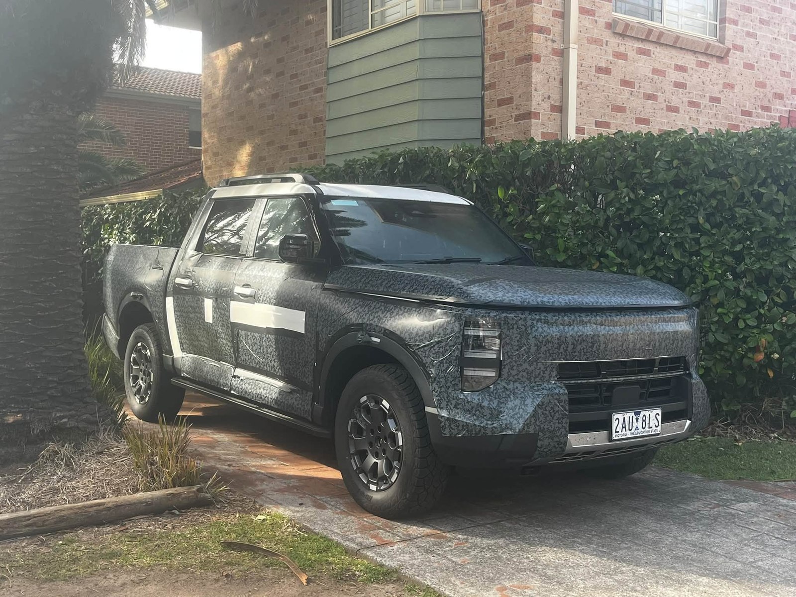 Camouflaged Nissan Frontier Pro prototype parked in a Sydney driveway