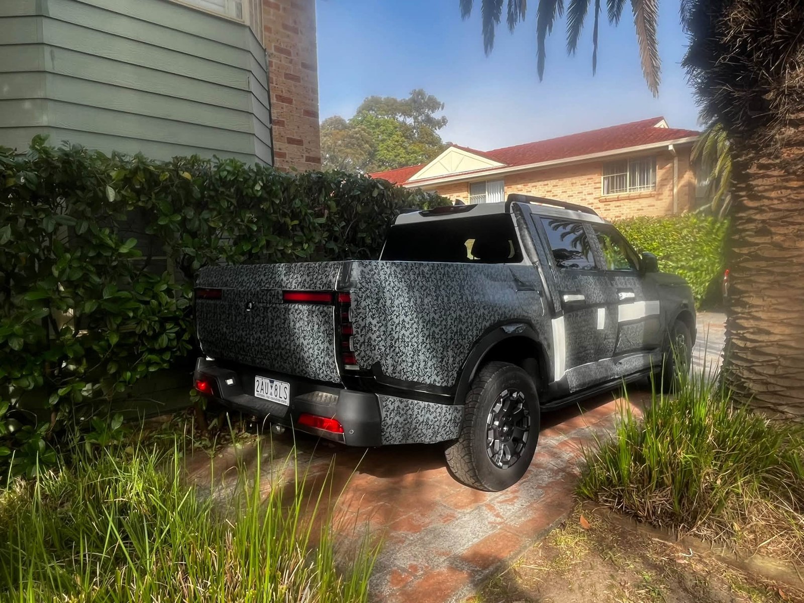 Rear view of a camouflaged Nissan Frontier Pro prototype in a Kirrawee driveway