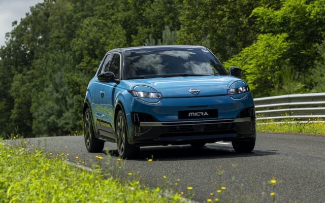 Blue Nissan Micra EV driving on a country road
