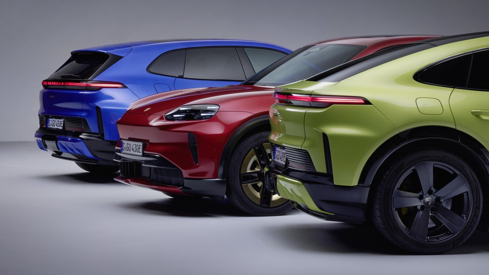 Three Porsche Cayenne Electric models in blue, red and green