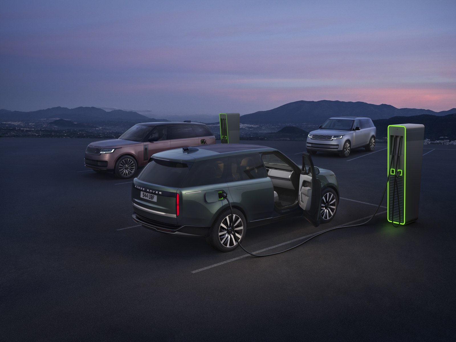 Two Range Rover Electrics at a charging station at dusk