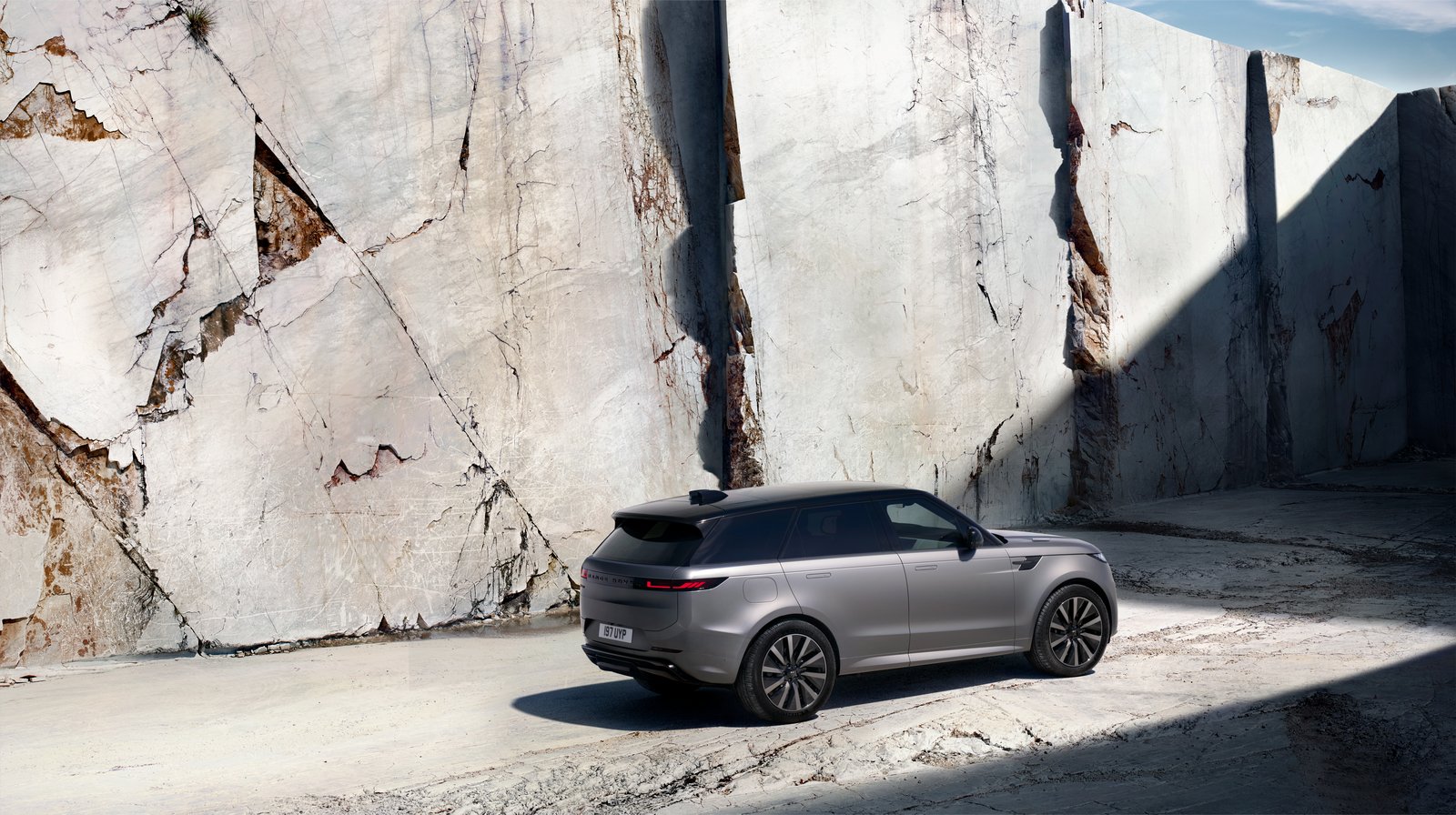 Rear three-quarter view of a grey Range Rover Sport Electric in a quarry