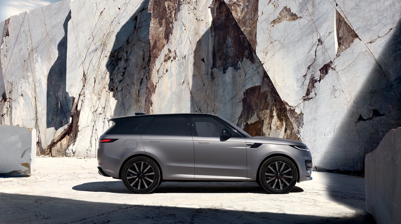 Side view of a grey Range Rover Sport Electric in a marble quarry