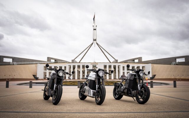 Three Savic C-Series electric motorcycles outside Parliament House in Canberra
