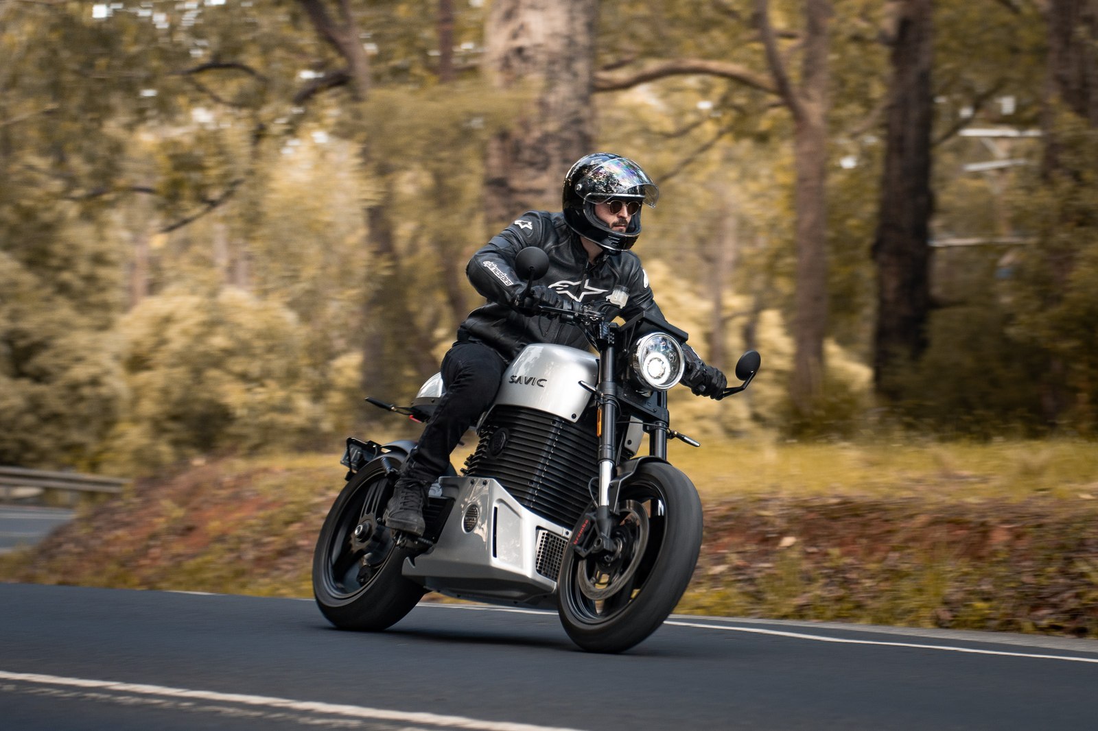 Rider on a Savic C-Series electric motorcycle on a country road