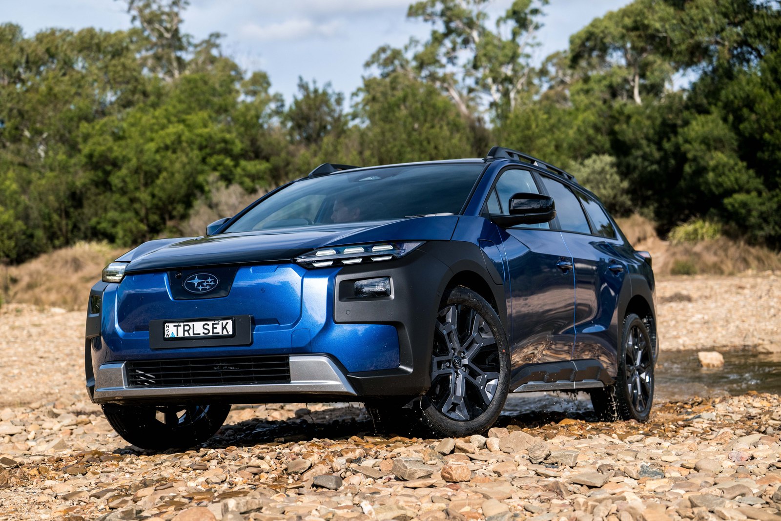 Blue Subaru Trailseeker AWD Touring on a gravel riverbed