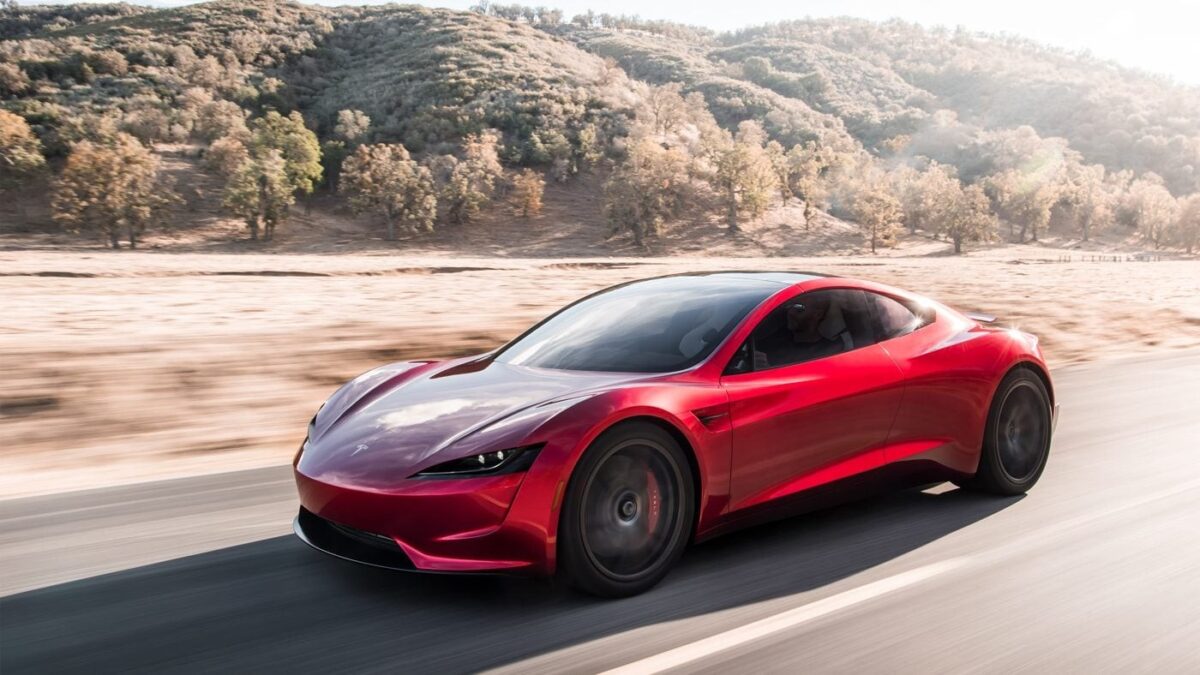 Red Tesla Roadster prototype driving on a desert road