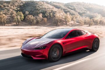 Red Tesla Roadster prototype driving on a desert road