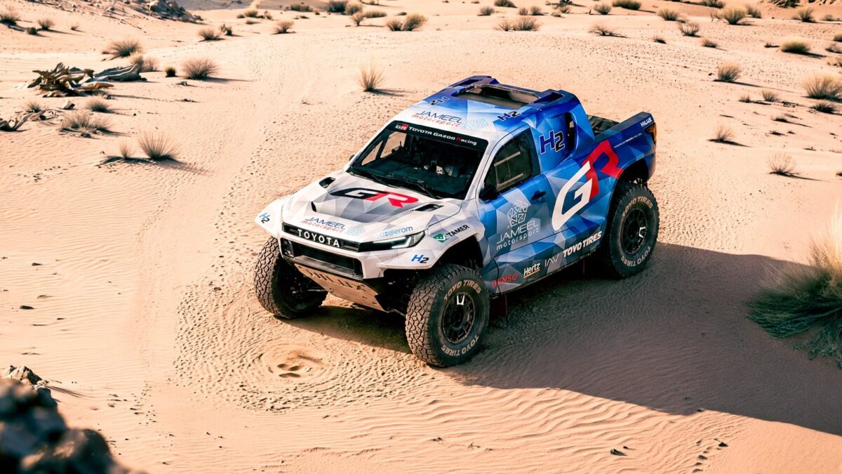 Toyota DKR GR FC Hilux hydrogen rally truck driving through sand dunes