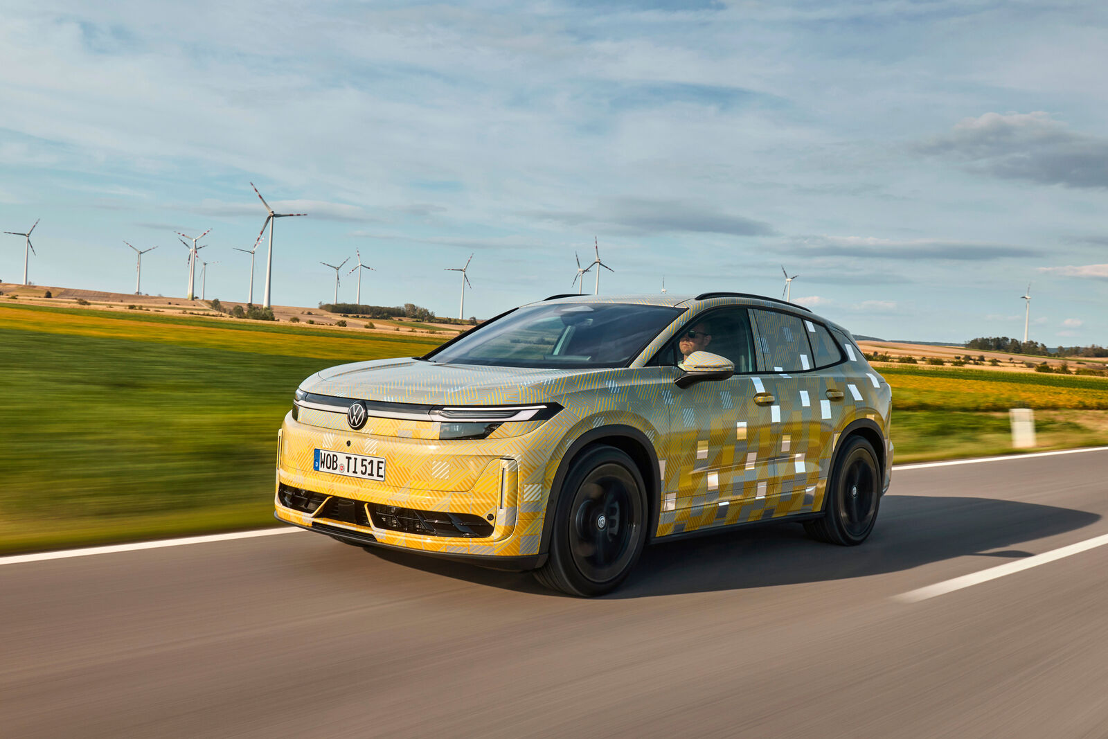 Front three-quarter view of a camouflaged Volkswagen ID. Tiguan prototype