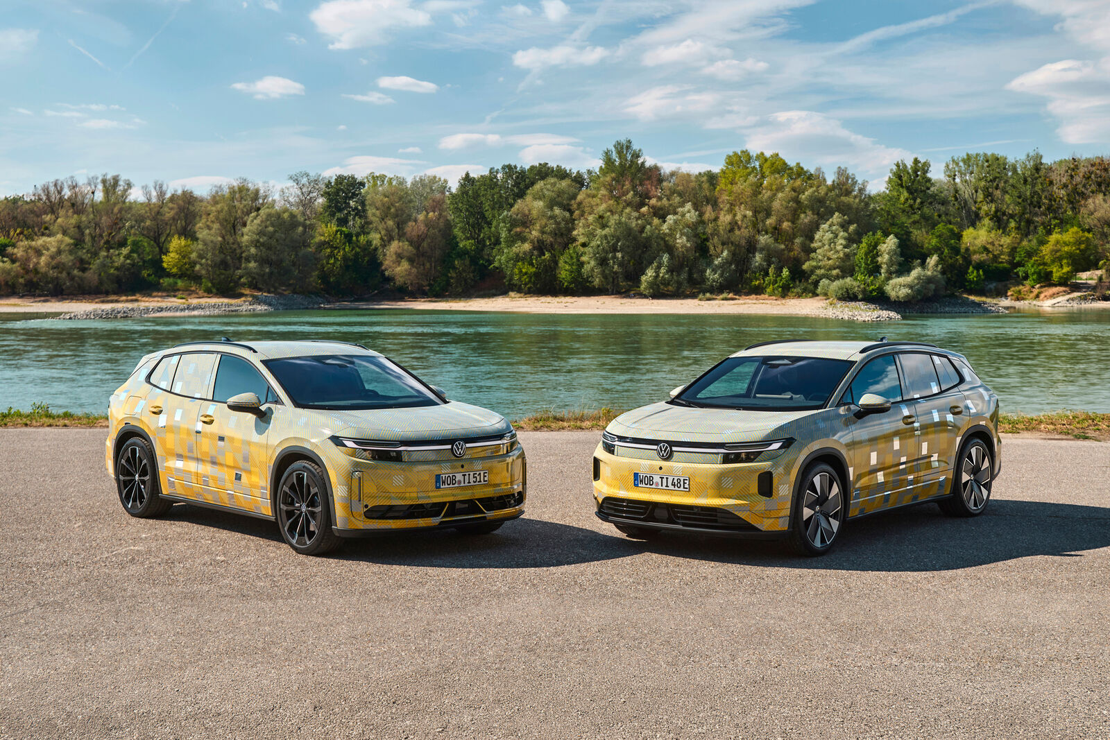 Two camouflaged Volkswagen ID. Tiguan prototypes parked beside a river