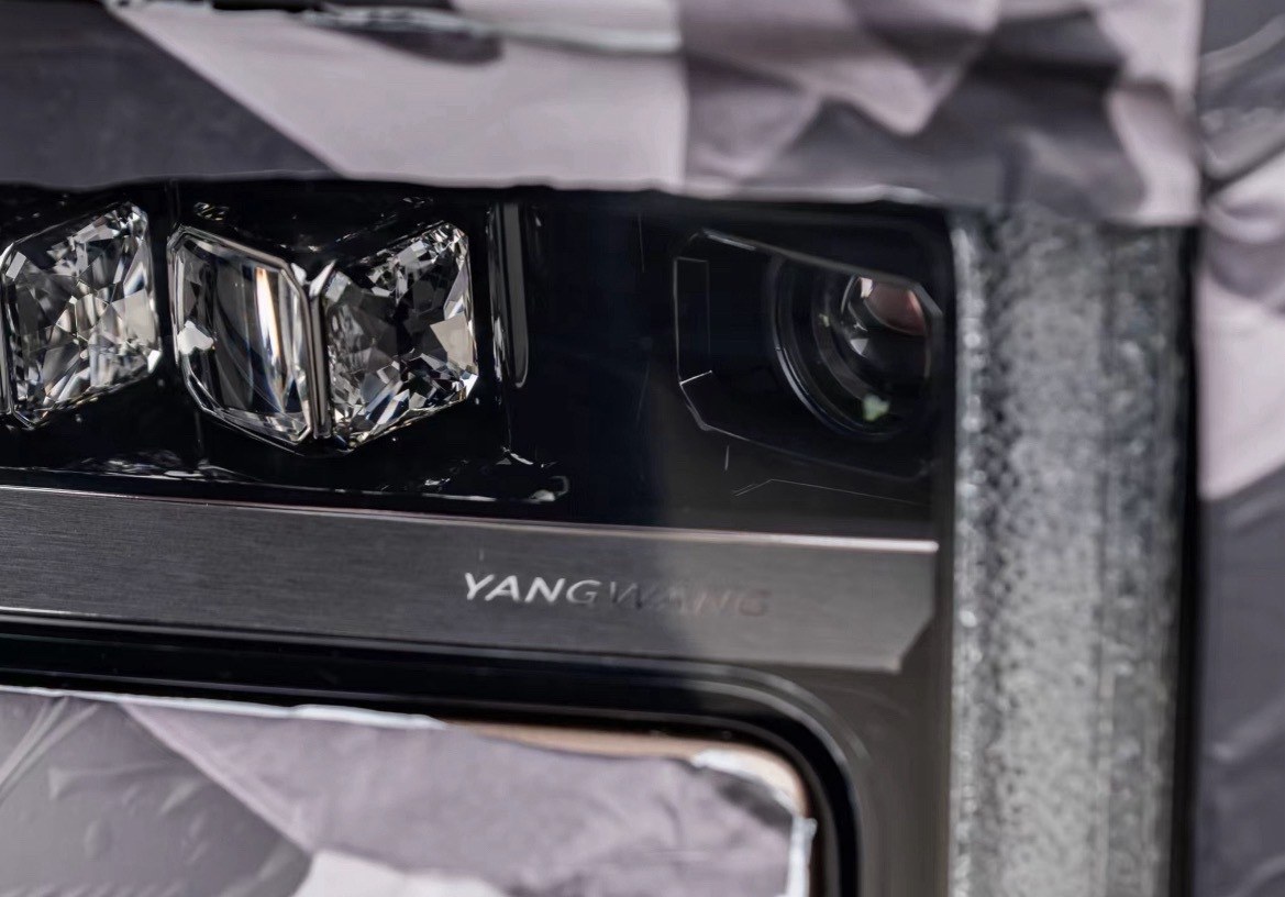 Close-up of the Yangwang sedan's headlamp with engraved logo