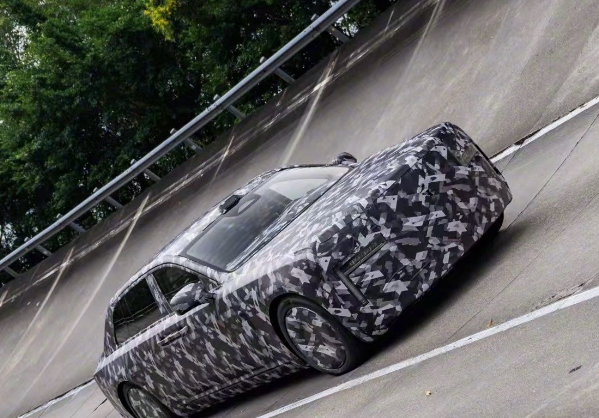 Camouflaged Yangwang sedan on a banked high-speed test track