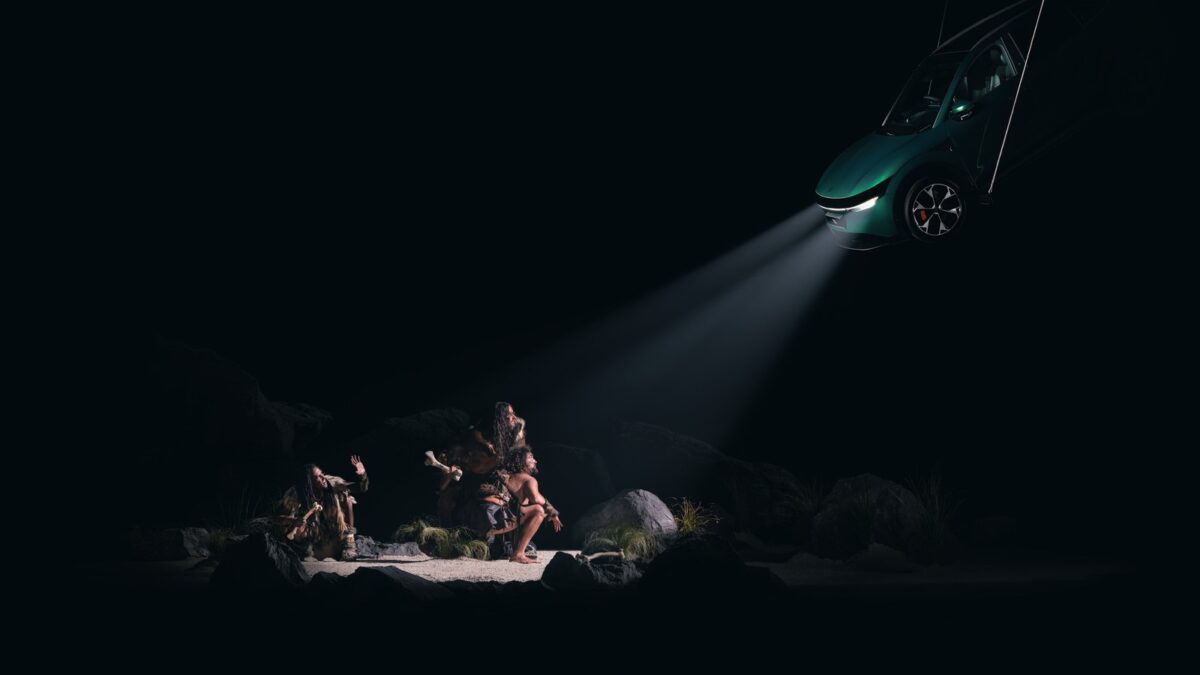 Caveman scene from Taika Waititi's Spotlight exhibition, lit by the headlights of a Zeekr 7X