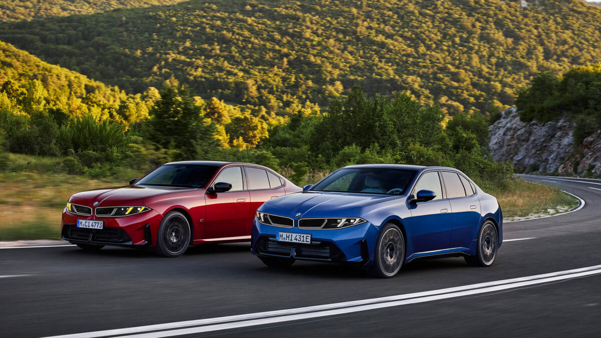 Blue BMW i3 and red BMW 3 Series sedans on a mountain road