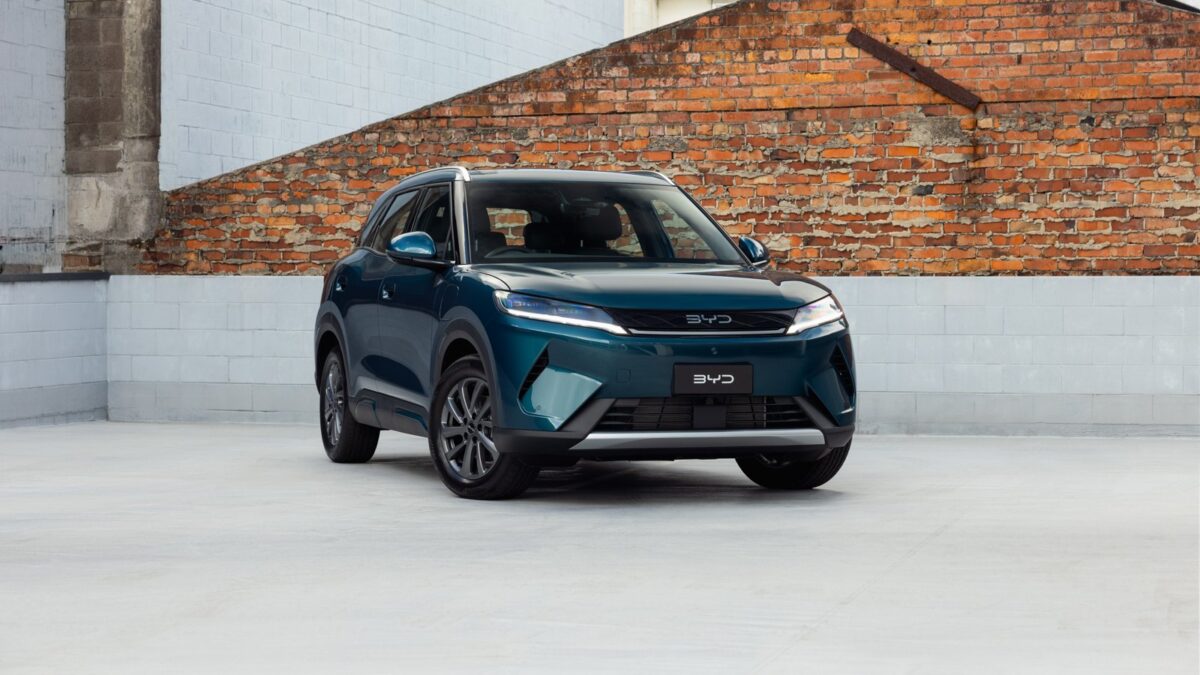 Teal BYD Atto 2 DM-i parked in front of a brick wall