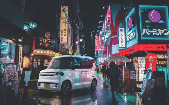White BYD Racco on a wet Tokyo street at night