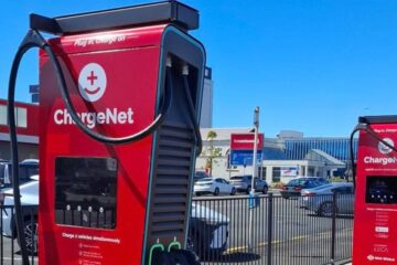Two red ChargeNet hyperchargers at a New World car park