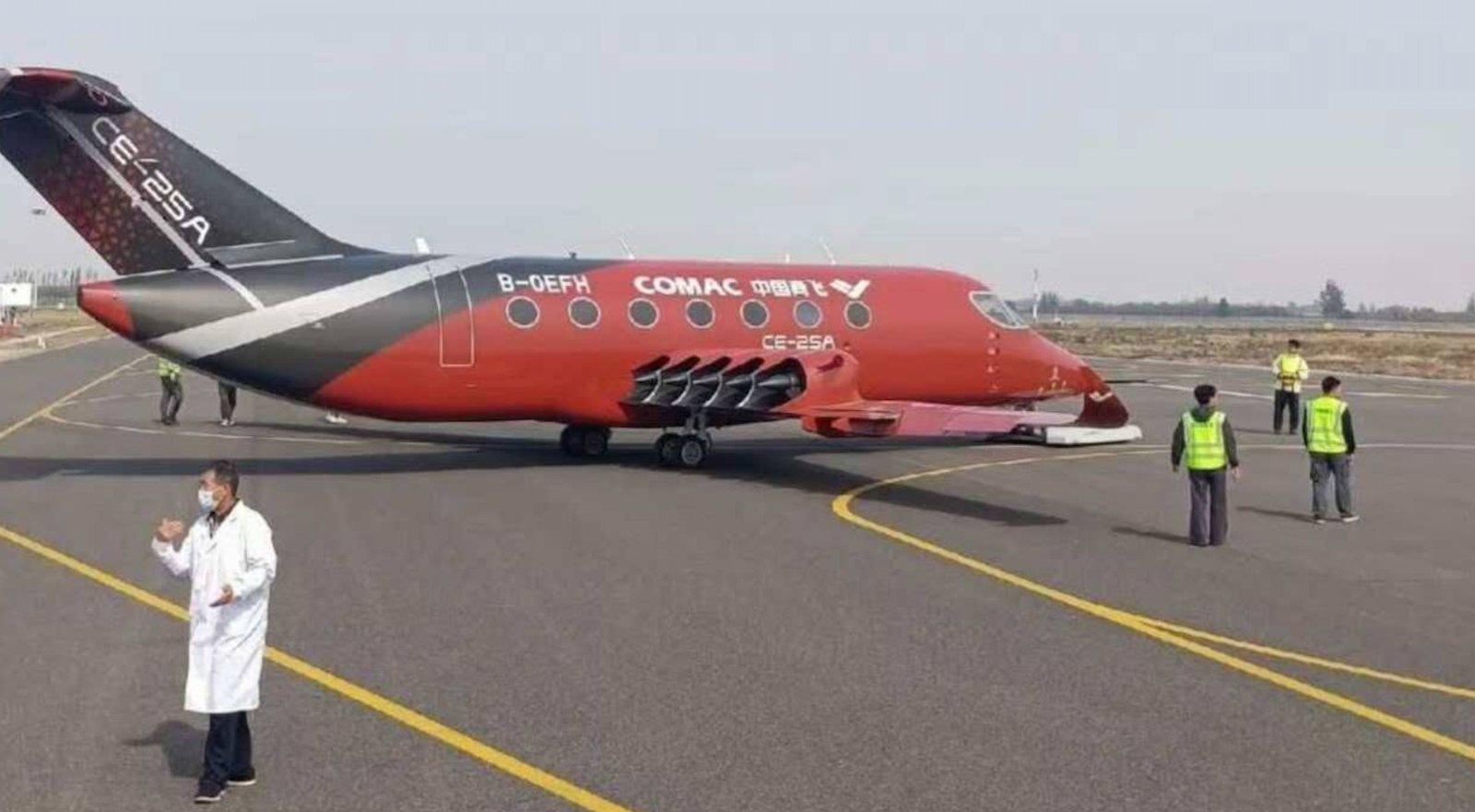 COMAC CE-25A electric aircraft side view on an airfield apron with ground crew