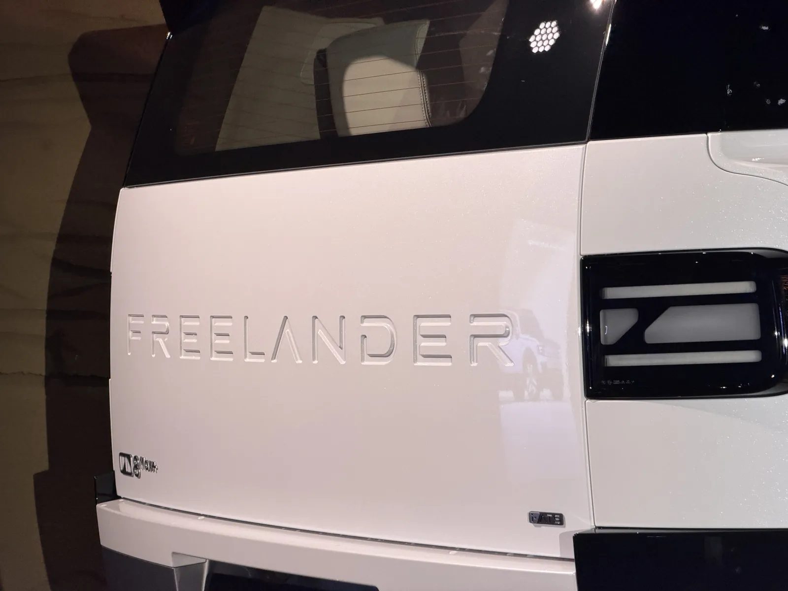 Freelander lettering carved into the tailgate of a white Freelander 8