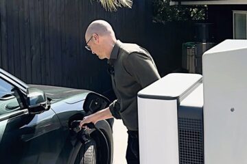James Ryan plugs a Geely EV into a StarCharge Halo bidirectional charger at home in Auckland